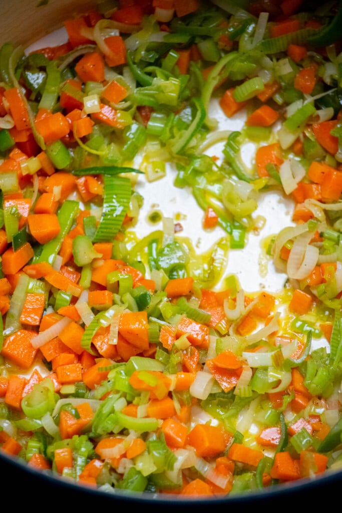 saut&eacute; carrots, celery and leeks in a large soup pot or dutch oven in olive oil, stirring occasionally until softened. 
