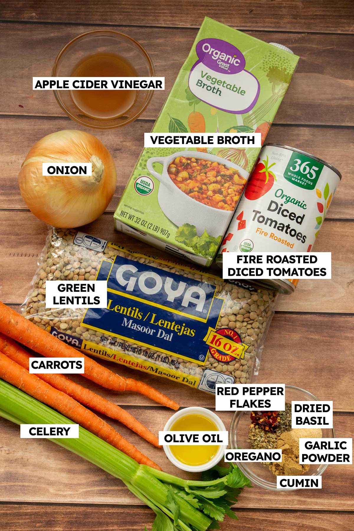 Ingredients for easy green lentil soup, including green lentils, carrots, celery, onion, fire-roasted tomatoes, vegetable broth, apple cider vinegar, olive oil, and spices.