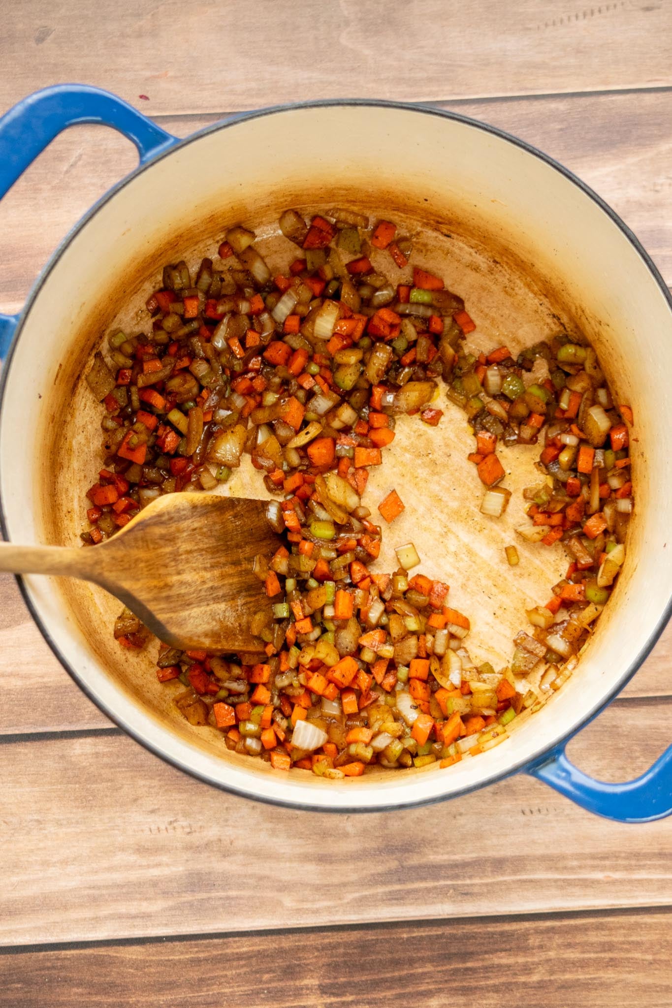 Sauté the vegetables. Add the onion, carrots and celery to the same pot. Season lightly with salt and pepper and cook until they begin to soften, scraping up the browned bits from the bottom.