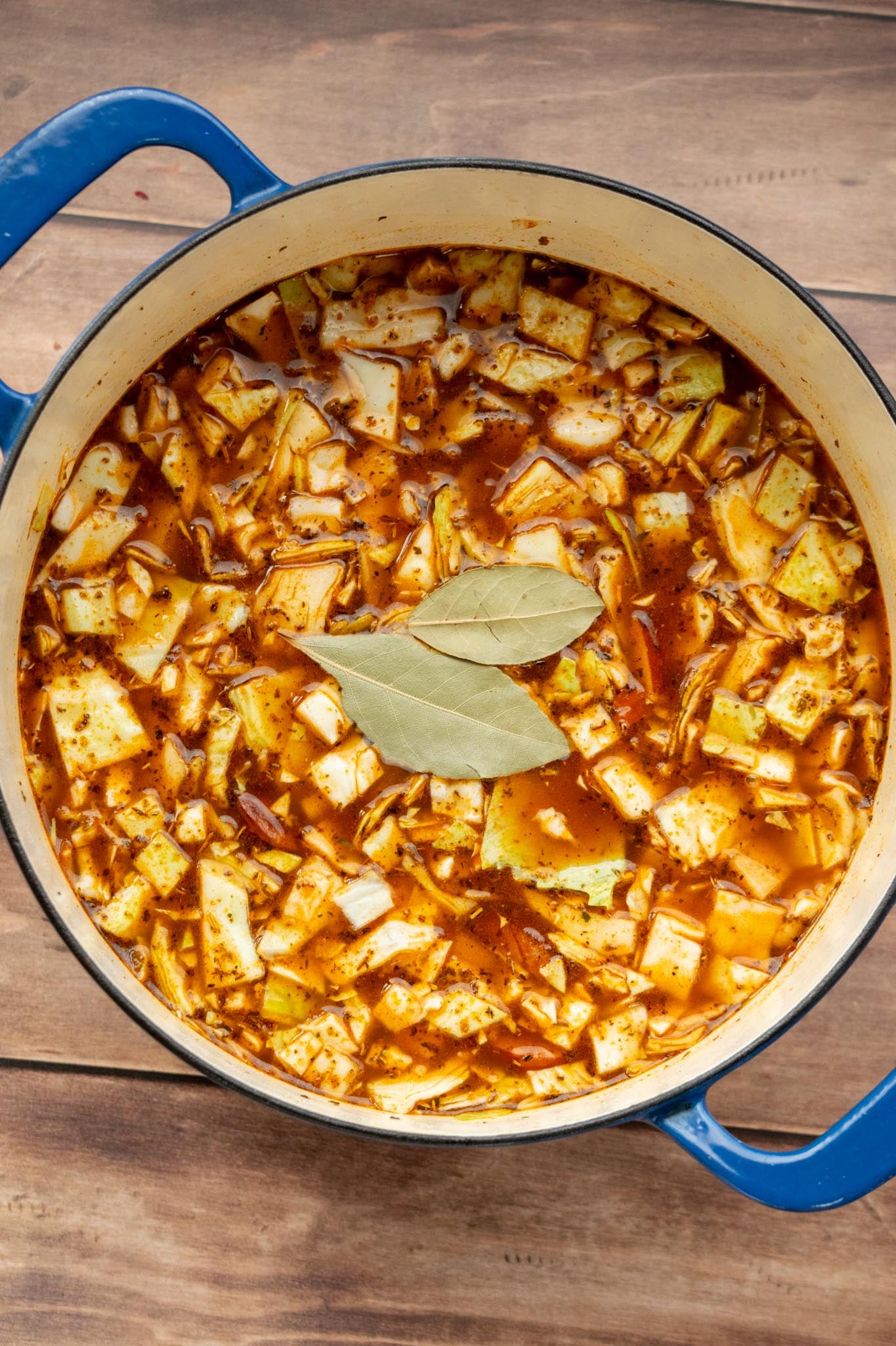 Simmer the soup. Add the cabbage, red potatoes, beef stock, chicken stock, bay leaves and browned kielbasa. Cover and simmer for 45–60 minutes, or until the cabbage and potatoes are tender.