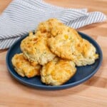 cheddar cheese biscuits on a serving plate.