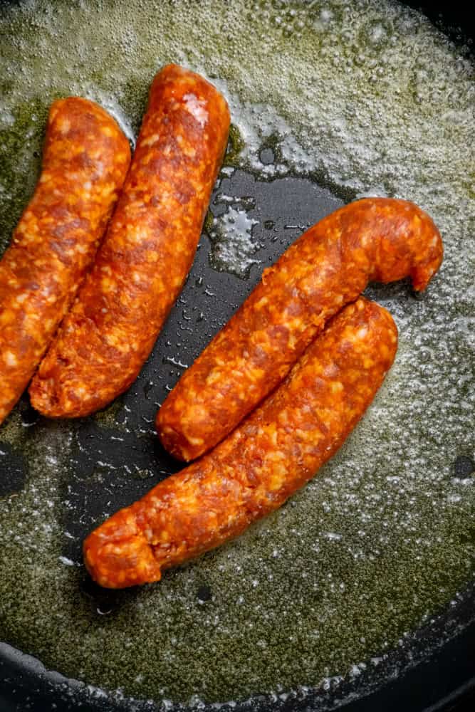 Heat butter and oil in pan until melted, remove sausage casings and add to pan.