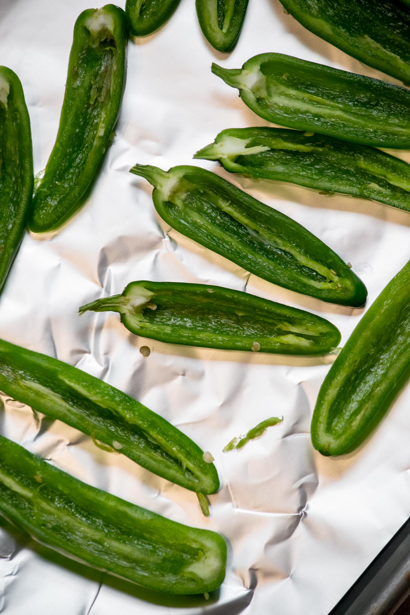 Arrange peppers on a foil of parchment lined baking sheet. If you plan to broil for extra crispiness, use aluminum foil- parchment can burn.