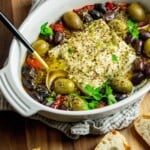 Easy Baked Feta with Olives and Roasted Red Peppers in. a baking dish with bread.