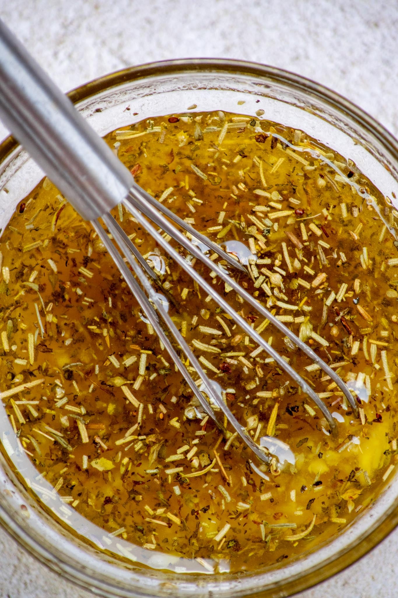 Whisk together olive oil, honey, minced or pressed garlic, and dried thyme, rosemary, basil and oregano until well combined.