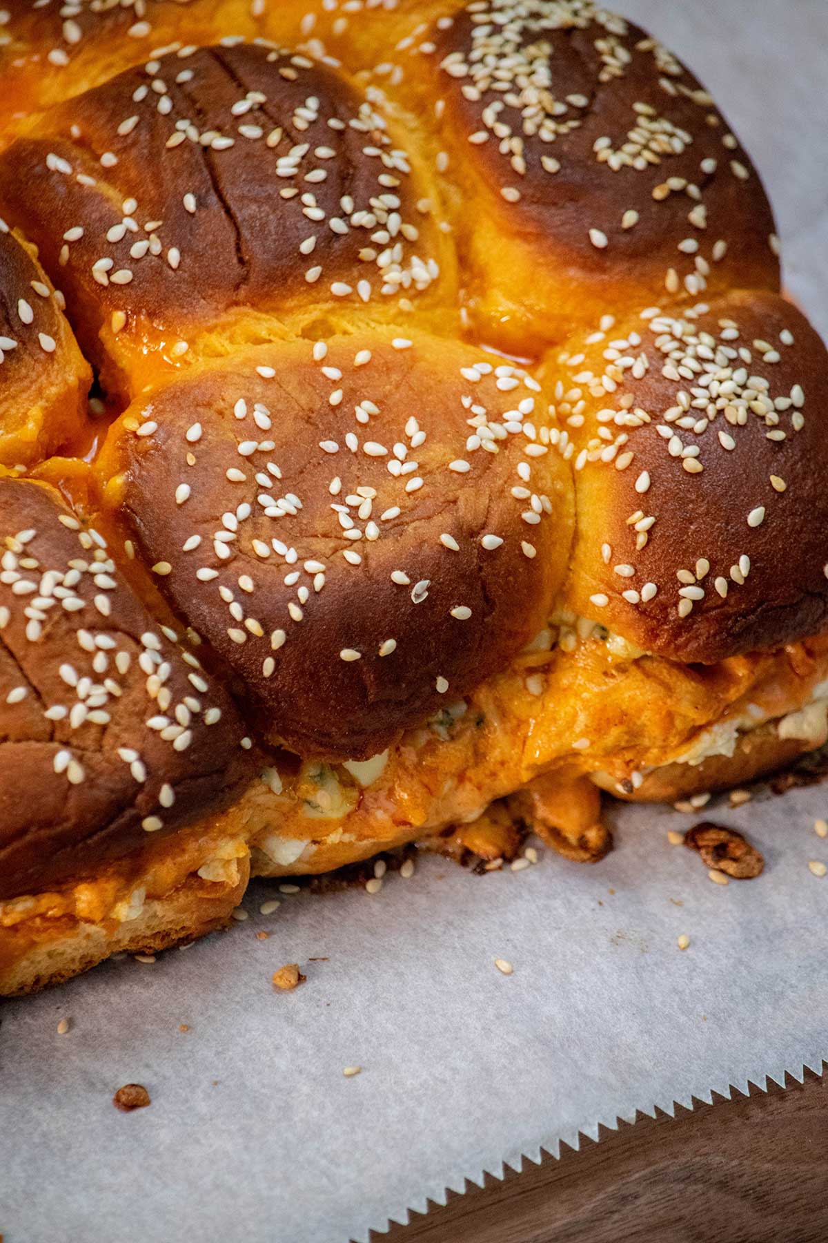 Bake.
Sprinkle with sesame seeds and bake for 15–20 minutes, until the cheese is melted and the tops are lightly golden. Let the sliders rest for a few minutes, then slice and serve warm.