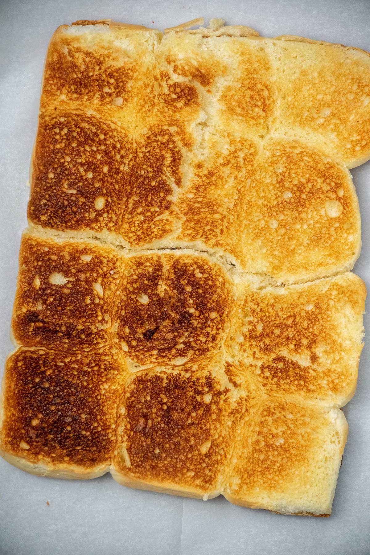 Toast the rolls.
Slice the rolls in half horizontally and lightly toast the cut sides under the broiler for 1–3 minutes. Transfer to a parchment-lined baking sheet and preheat the oven to 350°F.