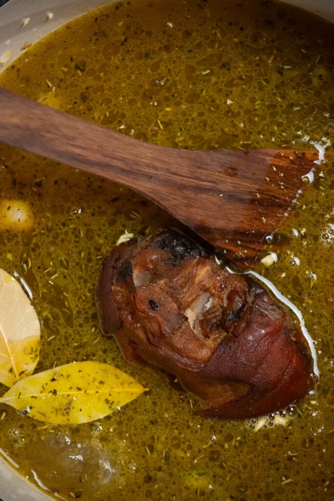 Add the chicken stock, water, ham hock, bay leaves, and green split peas, and bring to a boil over high heat. 