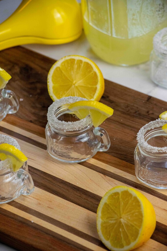 Run a lemon wedge around each shot glass, and dip in sugar to make the sugar rim