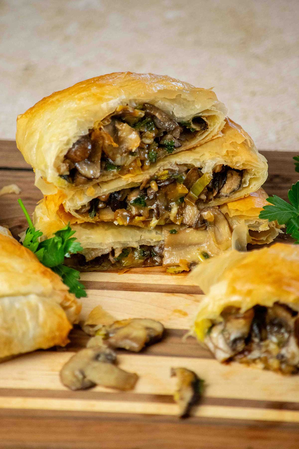 Pile of Vegetarian Strudel with Mushrooms and Leeks on a wood board.