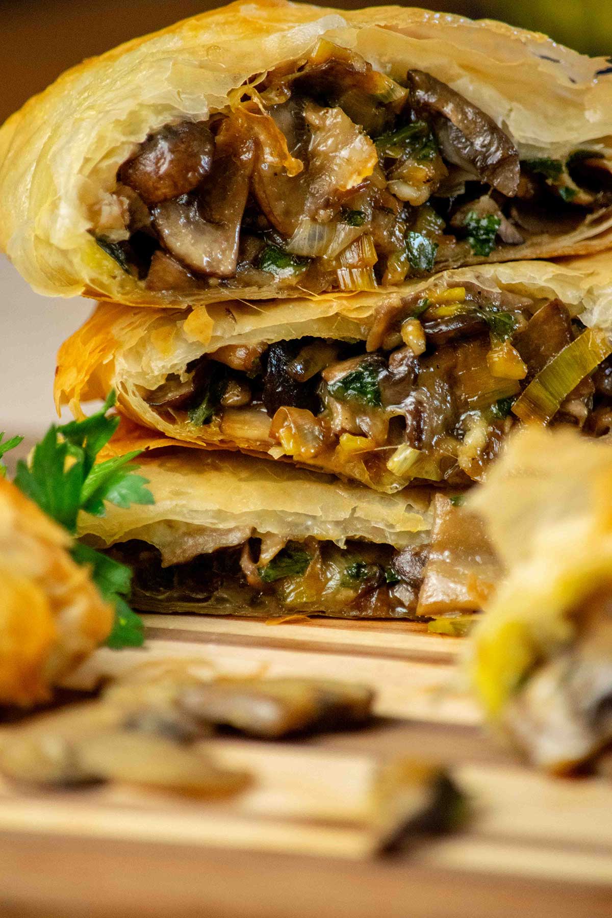 Vegetarian Strudel with Mushrooms and Leeks stacked in a pile on a cutting board.
