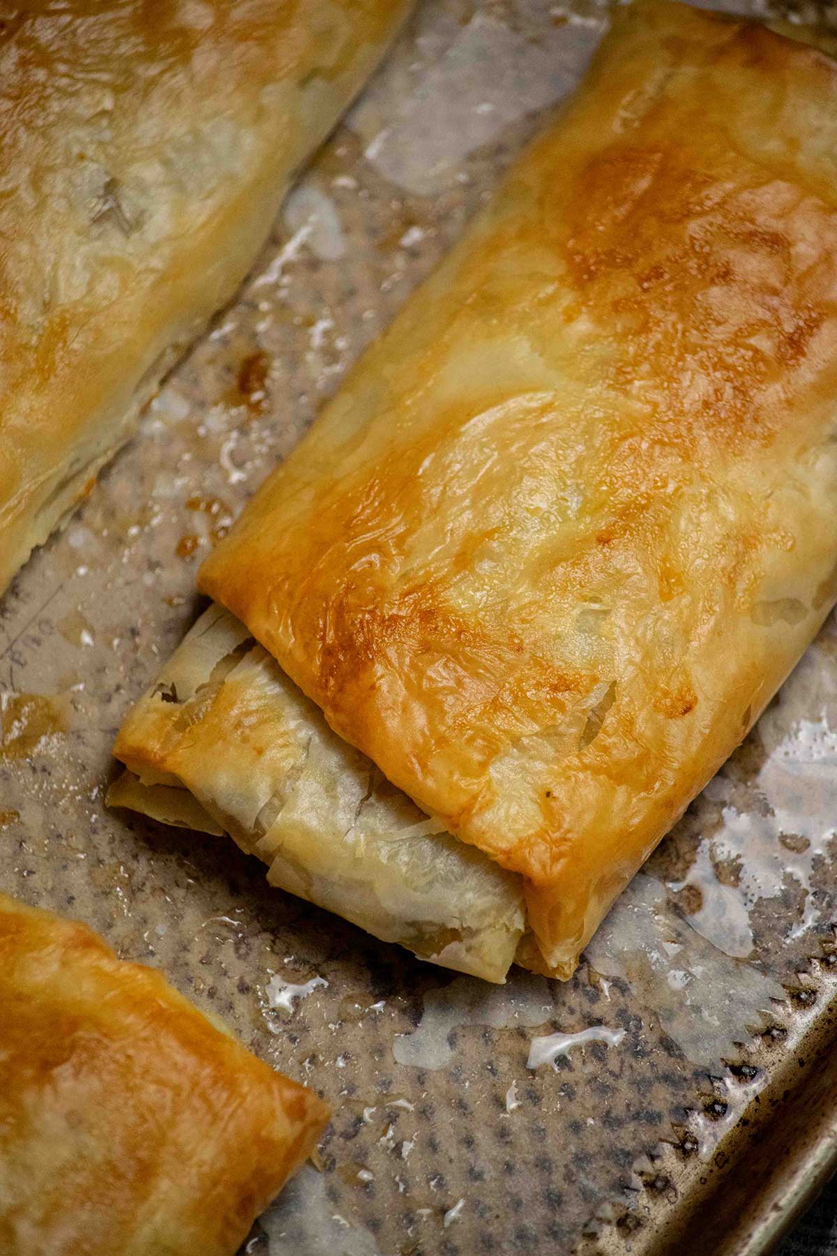 Brush and bake. Brush the tops with melted butter and bake at 400°F until golden brown and crisp, about 15 minutes. Let cool slightly, then slice and serve warm.
