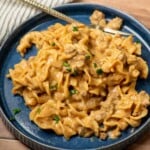 Homemade Hamburger Helper Beef Stroganoff with ground beef and egg noodles in a creamy sauce on a blue plate.