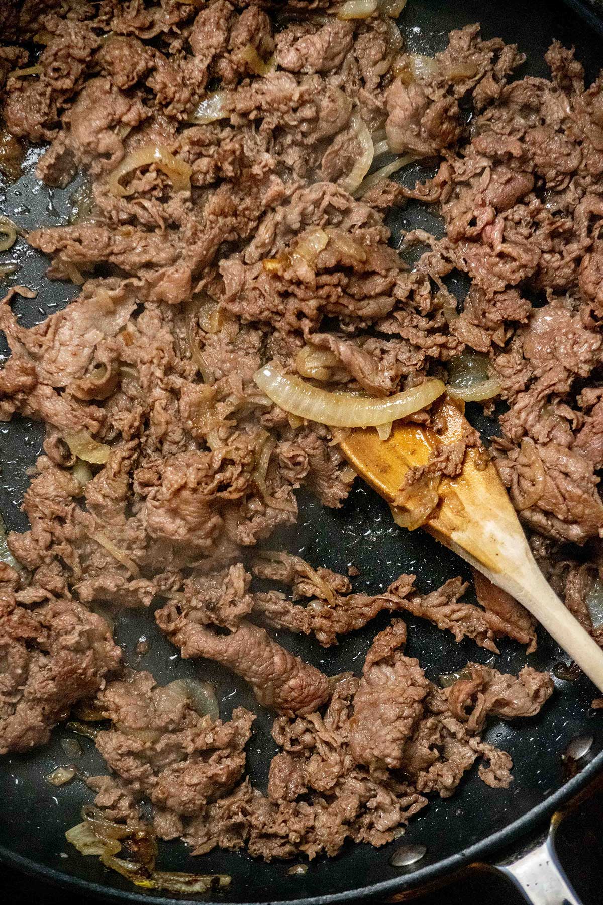 Cook the onions and steak.
Cook the onions over medium heat until softened and lightly browned. Add the shaved steak and cook just until no longer pink, breaking it apart as it cooks.