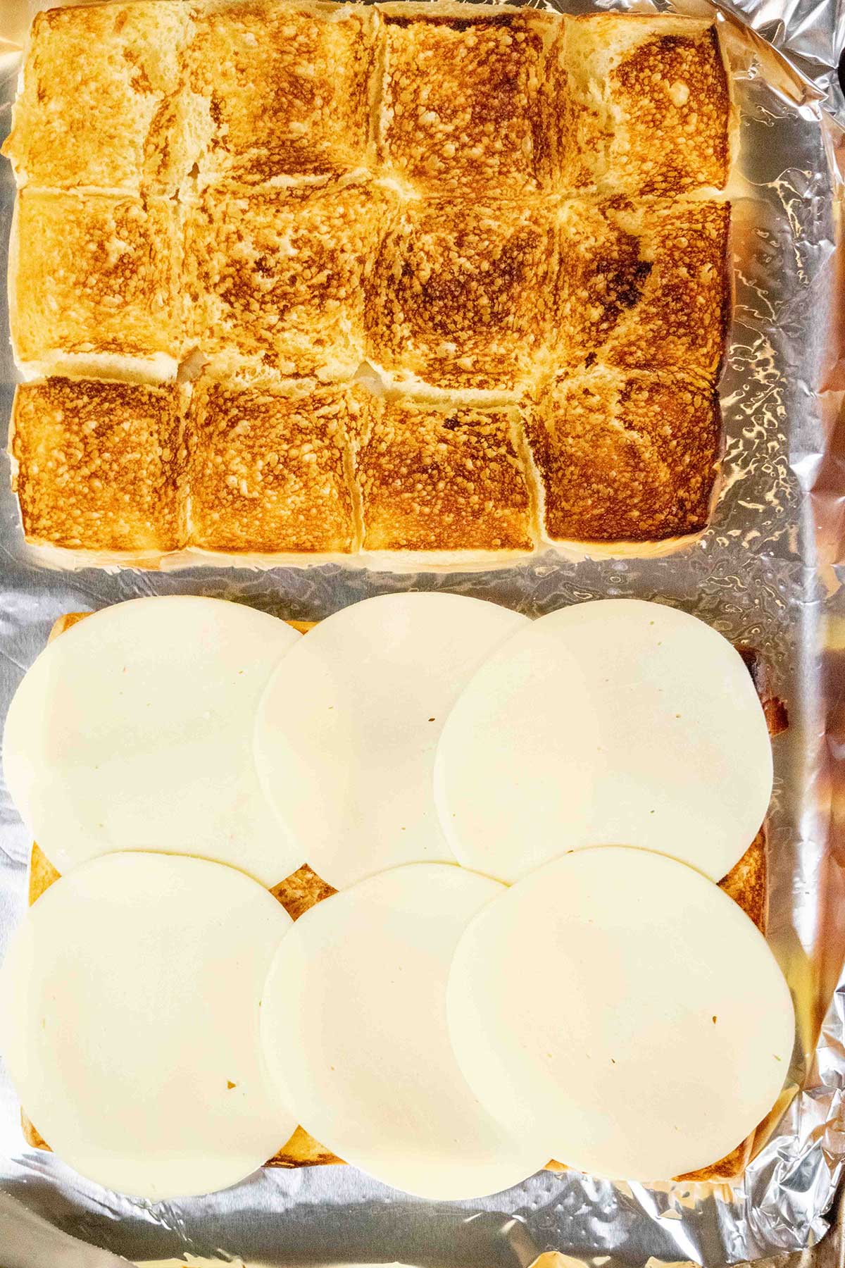 Toast the rolls.
Slice the rolls in half horizontally and lightly toast the cut sides under the broiler. Layer provolone over the bottom half.