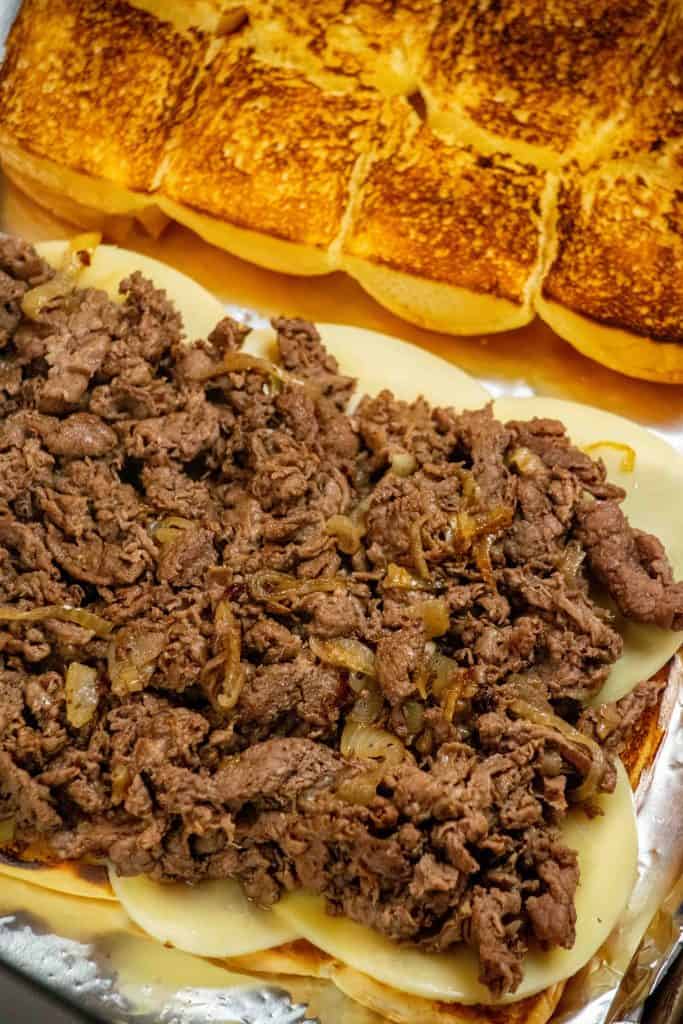 layer cooked steak and onions over provolone