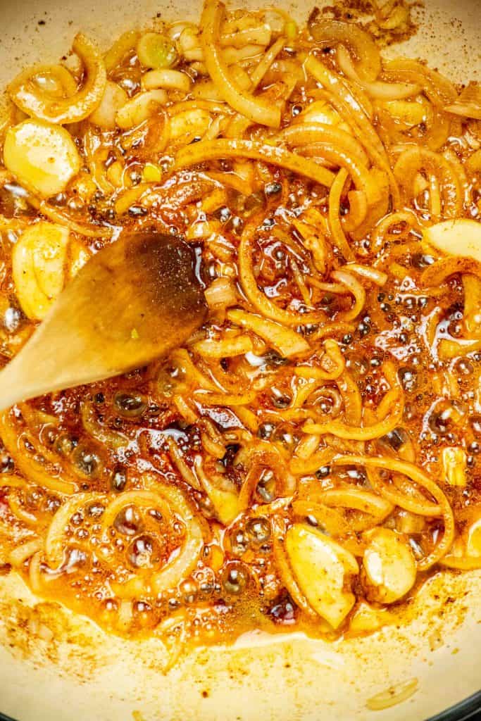 remove pork to a plate and set aside, and cook onions and garlic until slightly softened