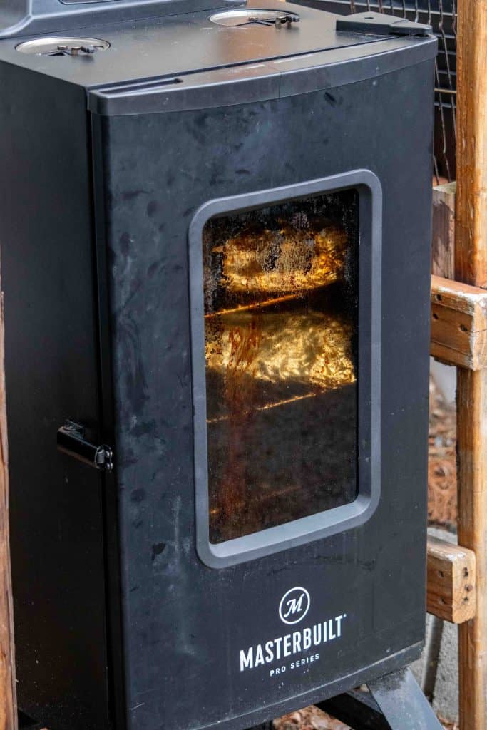 closed electric smoker with foil wrapped baby back ribs