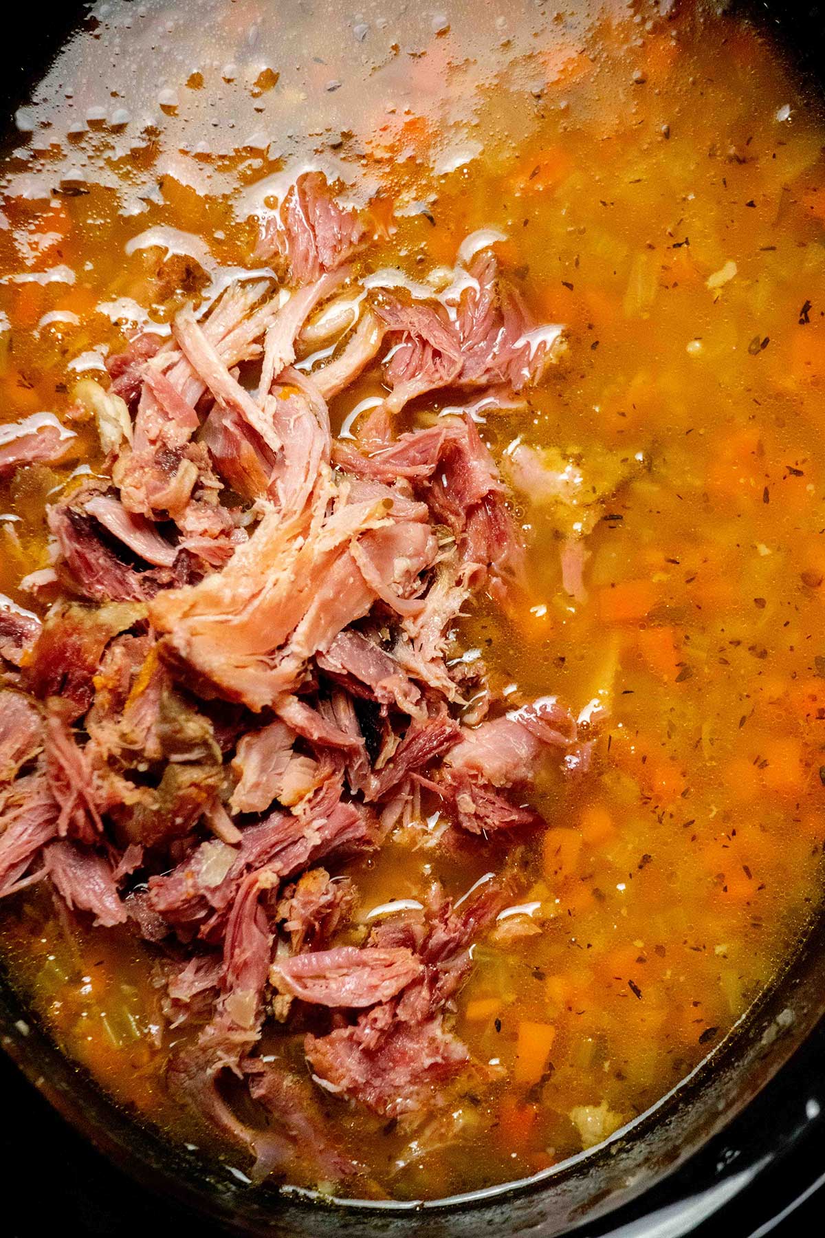 Shred the ham. Remove the ham bone, pull off the meat, and discard the bone and connective tissue. Return the shredded ham to the slow cooker.