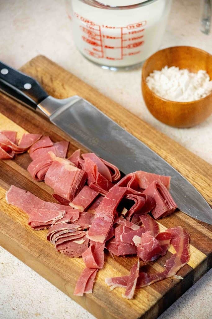 Melt butter in a medium saucepan, and slice dried beef