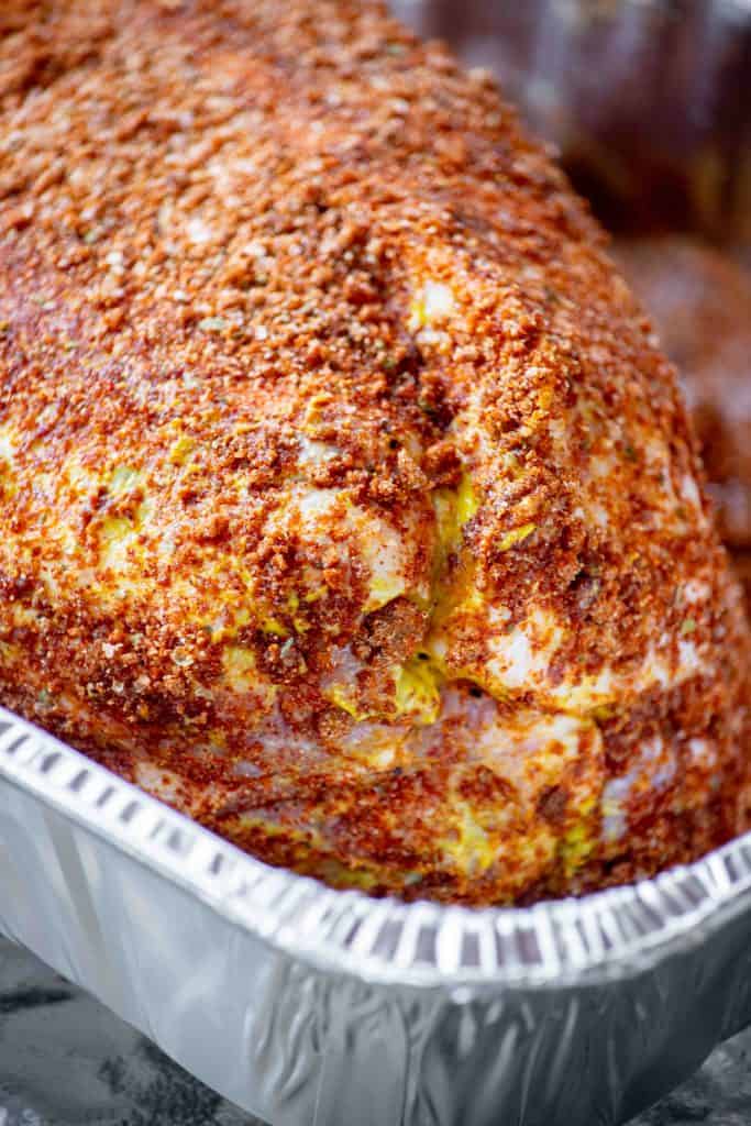 coat pork in rub, and place fat side up in foil pan