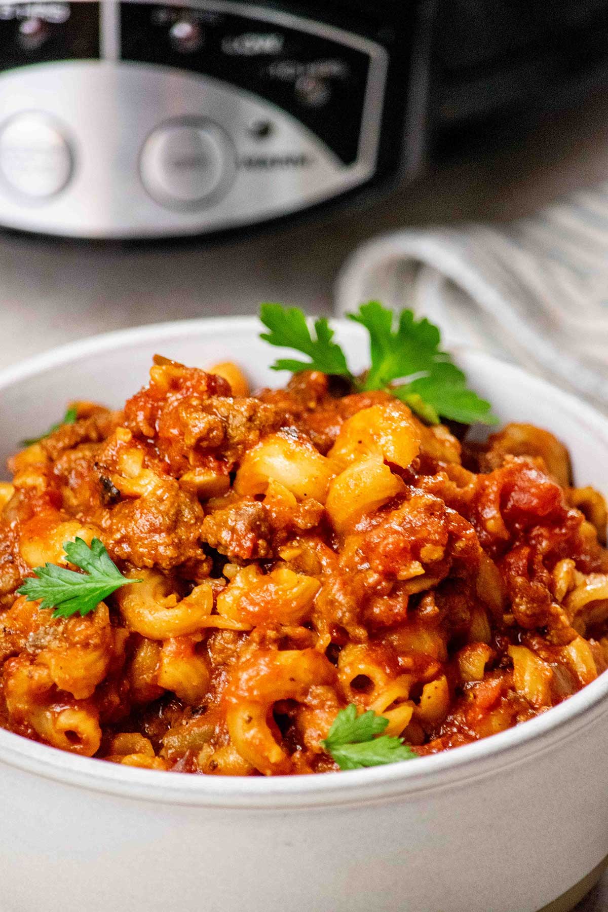 Closeup view of Crockpot Goulash recipe in a bowl with parsley on top.
