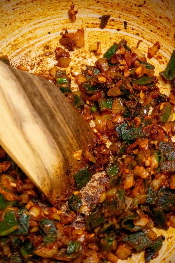 Cook onions in butter, then add garlic, spices, and peppers.