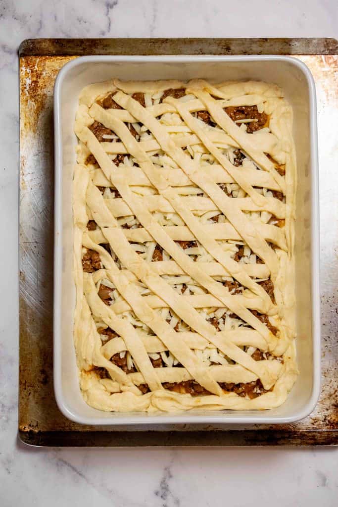 layer lengthwise, then across on an angle to create the lattice top, and seal edges with leftover dough strips 