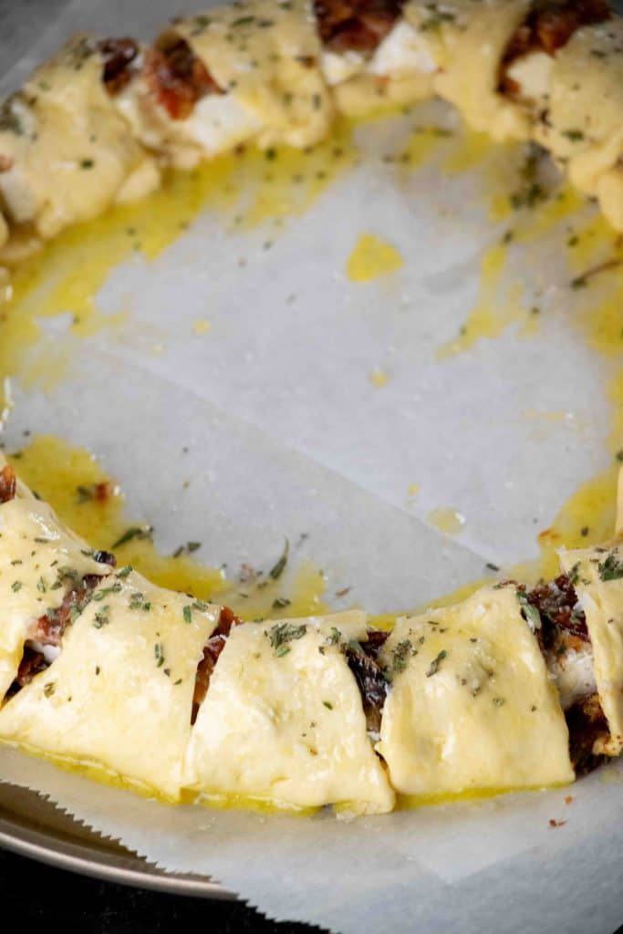 Brush wreath with beaten egg, and sprinkle on flakey salt, pepper, and rosemary