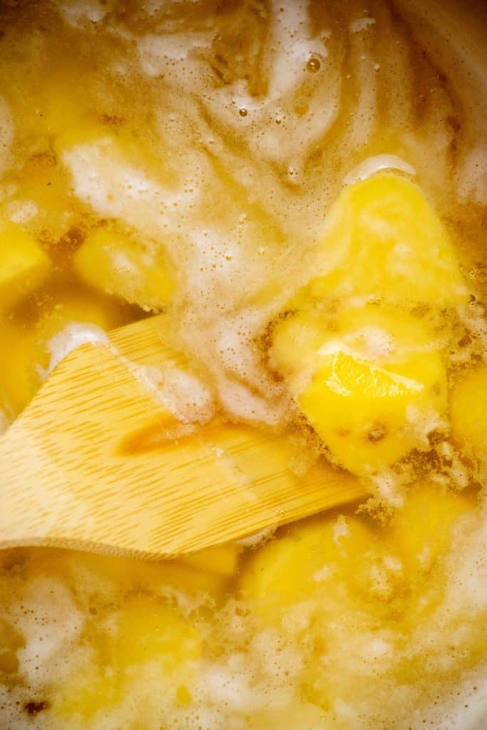 Preheat oven, and boil cut and peeled potatoes with salt and baking soda