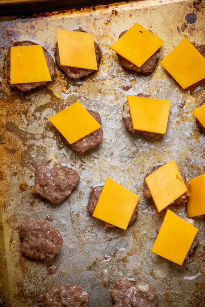 bake burgers on preheated sheet pan for 3-4 minutes, flip, and top with cheese