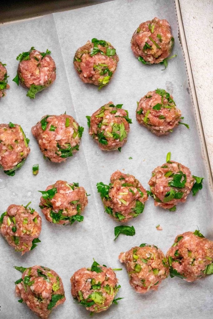 Form meatballs and arrange on a parchment lined baking sheet and bake in preheated oven