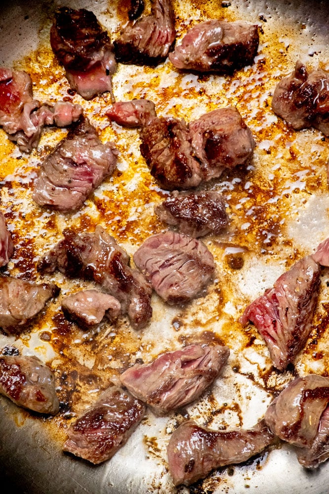 Brown the seasoned beef in a frying pan in oil until it forms a crust. No need to cook through, we're just looking for good color.