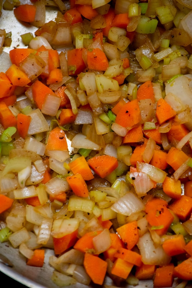Add the carrots, onion, and celery to the pan and cook until softened and most liquid is release, allowing you to loosen the browned bits from the pan.