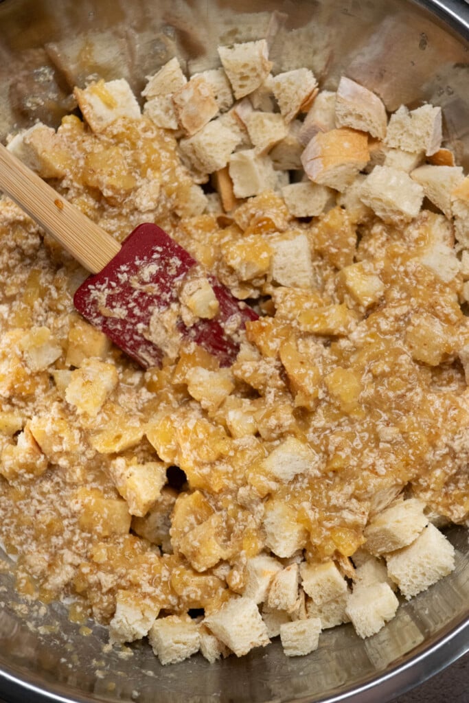 Add toasted bread cubes to a large mixing bowl, and pour mixture over top.