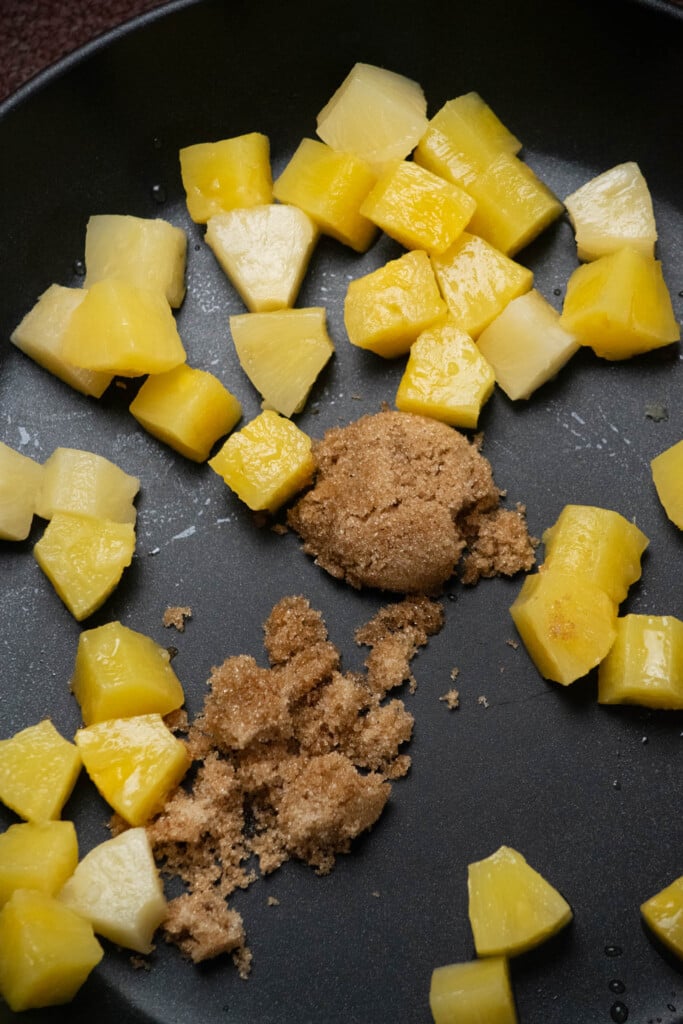 While your bread toasts, Add 2 tablespoon brown sugar and drained pineapple chunks to a large frying pan, and toss to coat.
