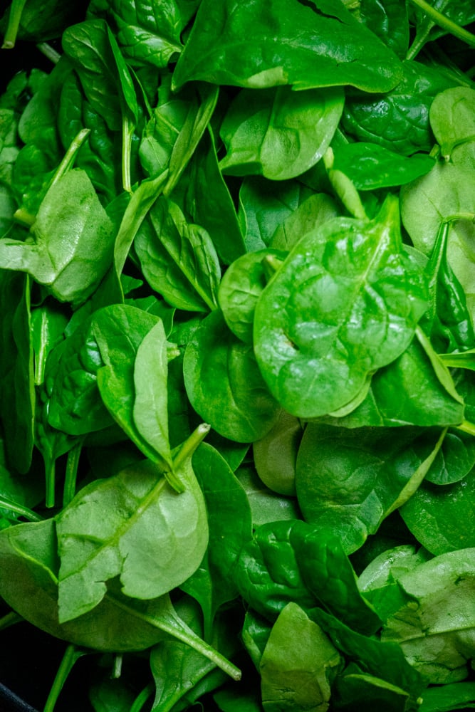 Immediately add all fresh baby spinach to the pan with the garlic and oil. Season with salt and pepper to taste.