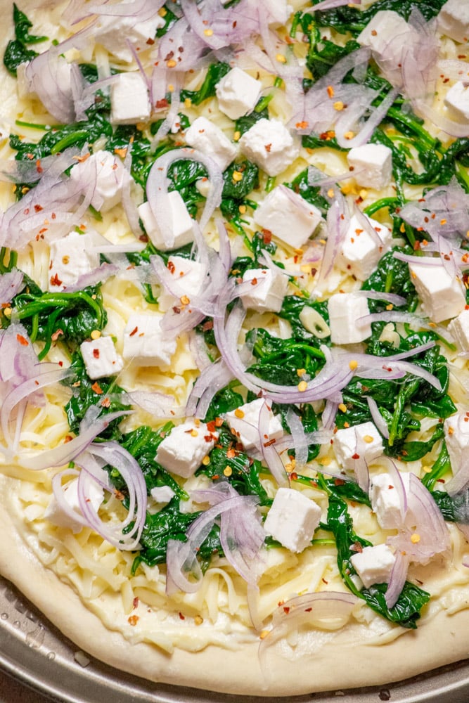 Lastly, add your thinly sliced red onion on top, and a sprinkling of crushed red pepper flakes.