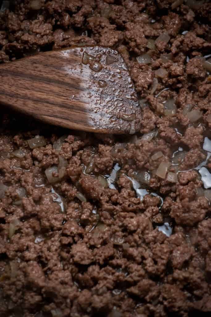 cook ground beef, breaking the meat up as you go until browned and cooked through, then remove any excess grease by draining or blotting with paper towels. 