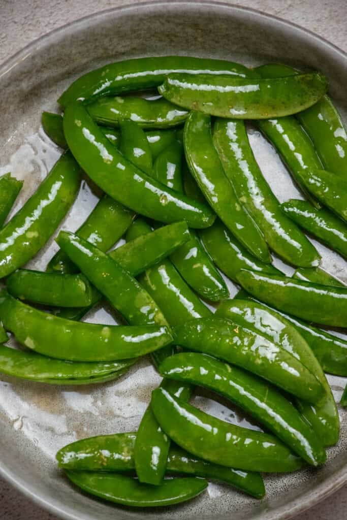 While the dumplings and veggies bake, toss trimmed snap peas in reserved toasted sesame oil. 