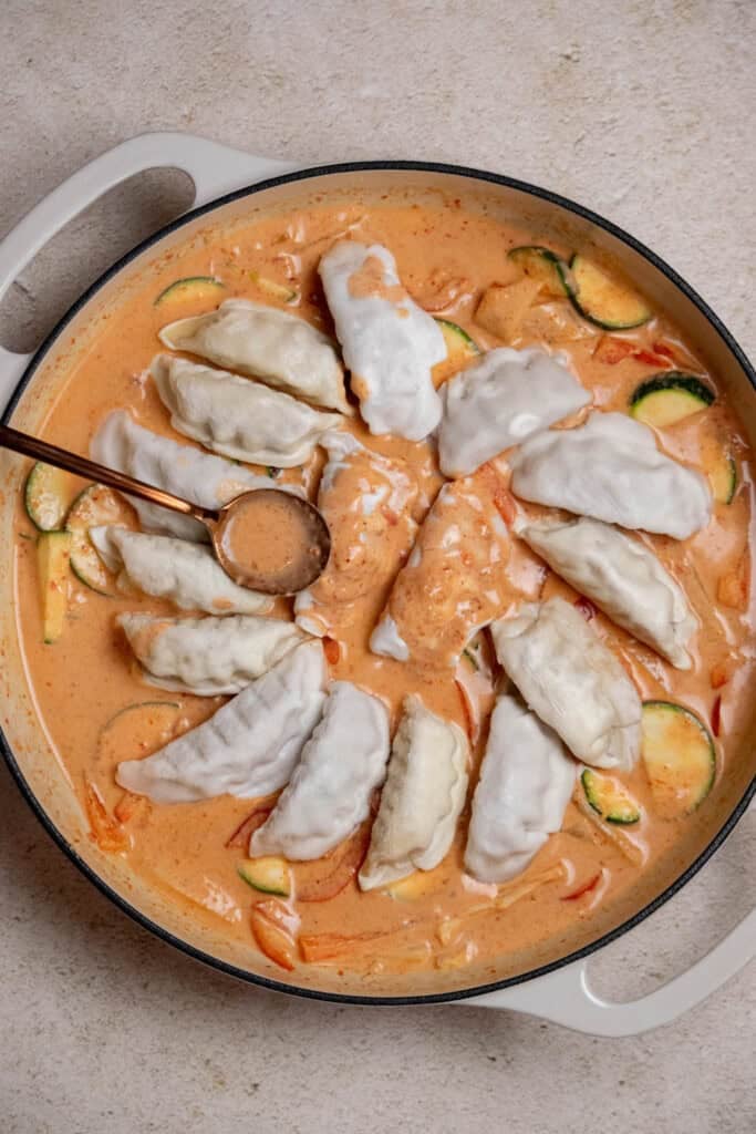 arrange dumplings over the veggies and sauce, so they are on top of the bed of veggies, but not submerged. Spoon sauce over the dumplings. 