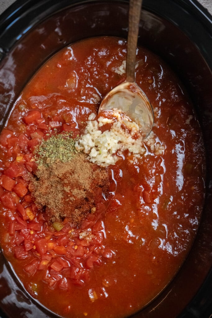 add salsa, adobo sauce, dried spices, diced tomatoes and green chilis, and garlic to the crockpot