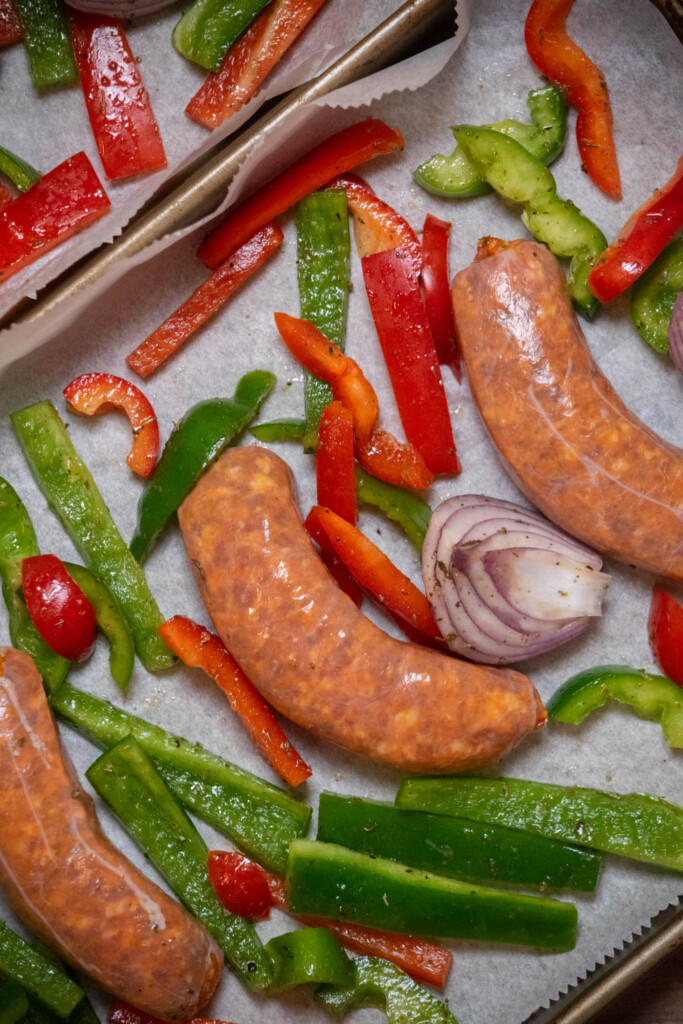 roast the sausages and veggies in a preheated oven, flipping the sausages after 15 minutes to promote even browning