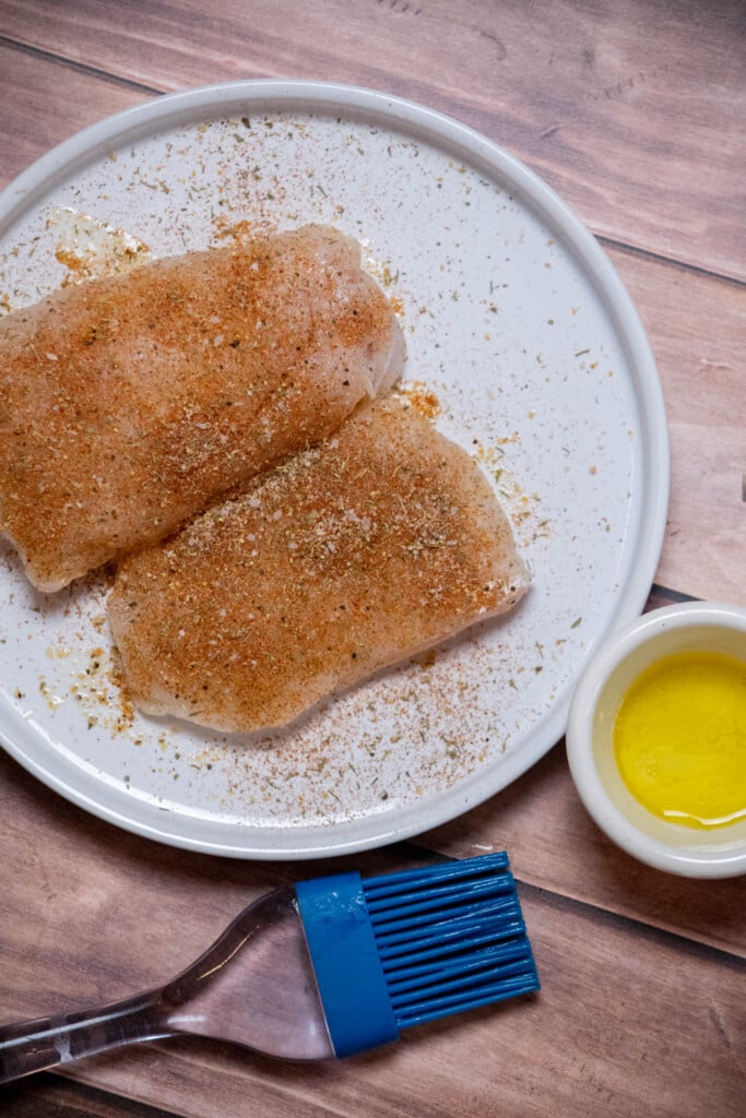 brush both sides of each cod filet with olive oil, until well coated, then sprinkle seasoning blend evenly over all sides 
