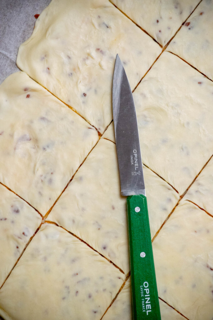using a sharp knife, trim the edges to make a clean edge, and cut into 12 equal squares. Repeat all steps with remaining sheet of puff pastry. 