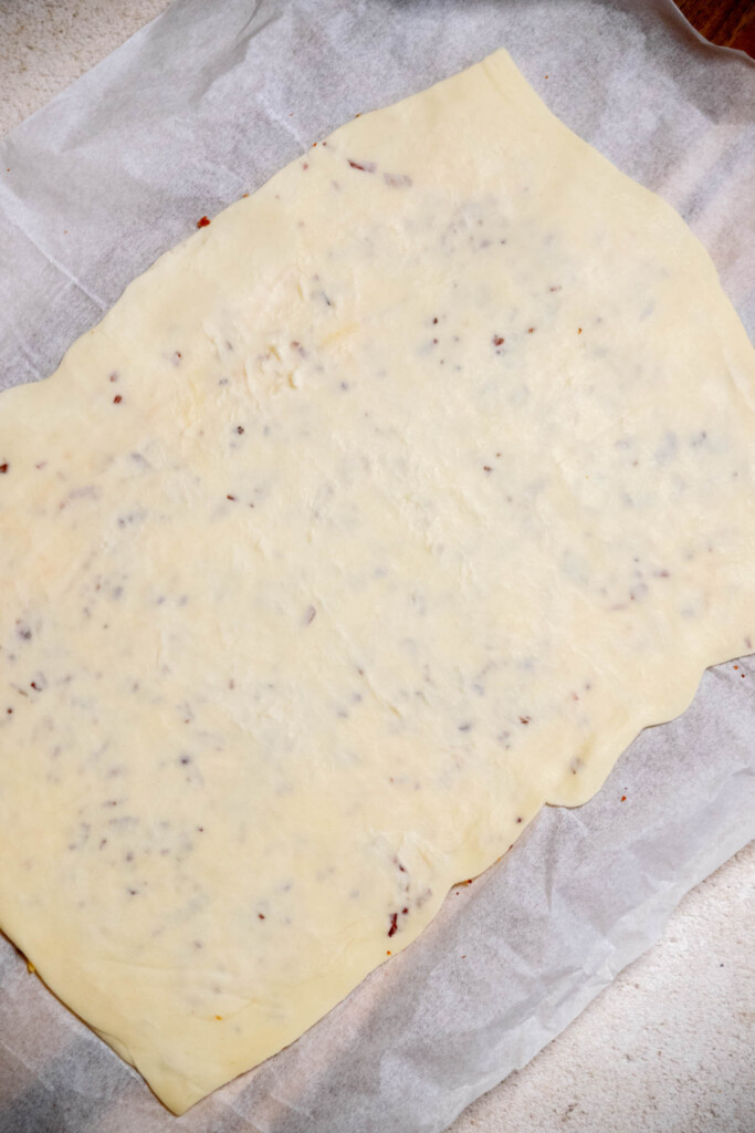 using a rolling pin, roll out the sealed dough until it is roughly 12" long. 