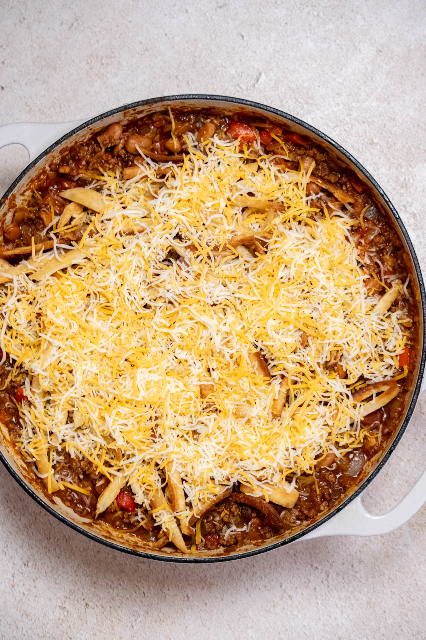 Turn off heat, and cover the meat mixture with an even layer of the reserved tortilla strips, and top with cheese. 