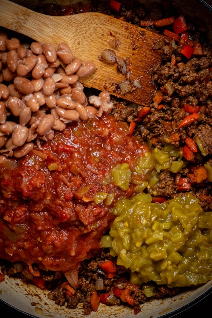 Add salsa, diced chilis and pinto beans, stir to combine, and simmer until warmed through, about 7 minutes 