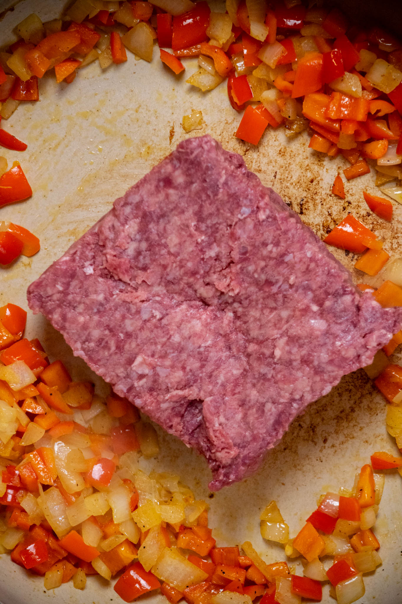 Move onions and peppers to the outer edge of the pan, and add your ground beef to the center.