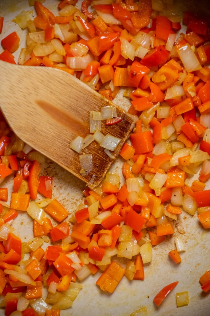 remove all but 1 tablespoon of oil from the skillet, and add the peppers and onions. Season with salt and pepper and cook, stirring occasionally, until slightly softened